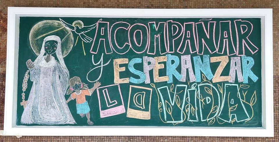 Grupo diverso de estudiantes y profesores en una biblioteca moderna y luminosa del campus.