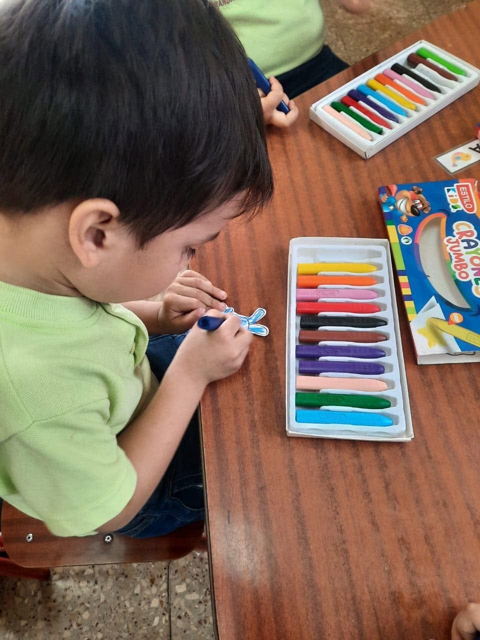 Niños de preescolar jugando con bloques educativos de colores en un aula luminosa.
